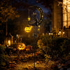 A Halloween solar garden stake light featuring a black cat moon pumpkin lantern in a dark outdoor setting.