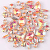 A mix of iridescent glass rhinestones in jelly candy AB colors, shaped like claws and various facets.