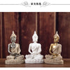 Three handcrafted resin Buddha statues in various finishes seated for meditation and decor