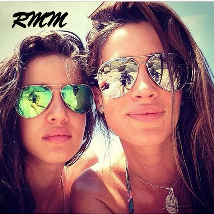 Two women wearing classic pilot sunglasses with mirror lenses looking at the camera.