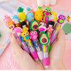 A hand holds a set of five cute cartoon mini ballpoint pens featuring various colorful characters and designs.