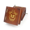 A classic wooden hand-crank music box with carved details, featuring a tiger face design.