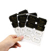 A hand holds several black thank you seal stickers for crafting and packaging.