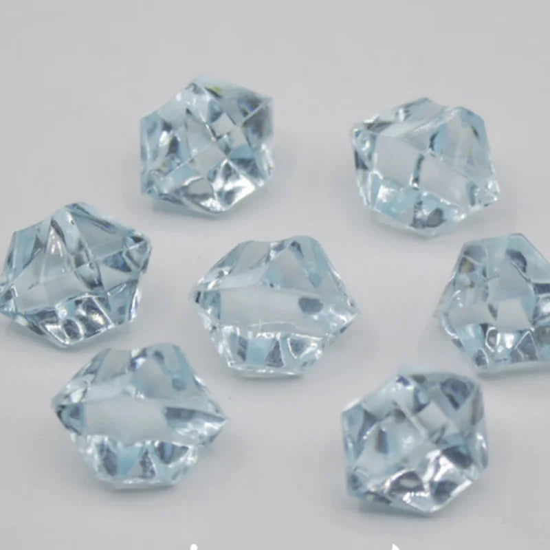 A collection of clear blue acrylic crystal decorations shaped like pyramids and facets for parties