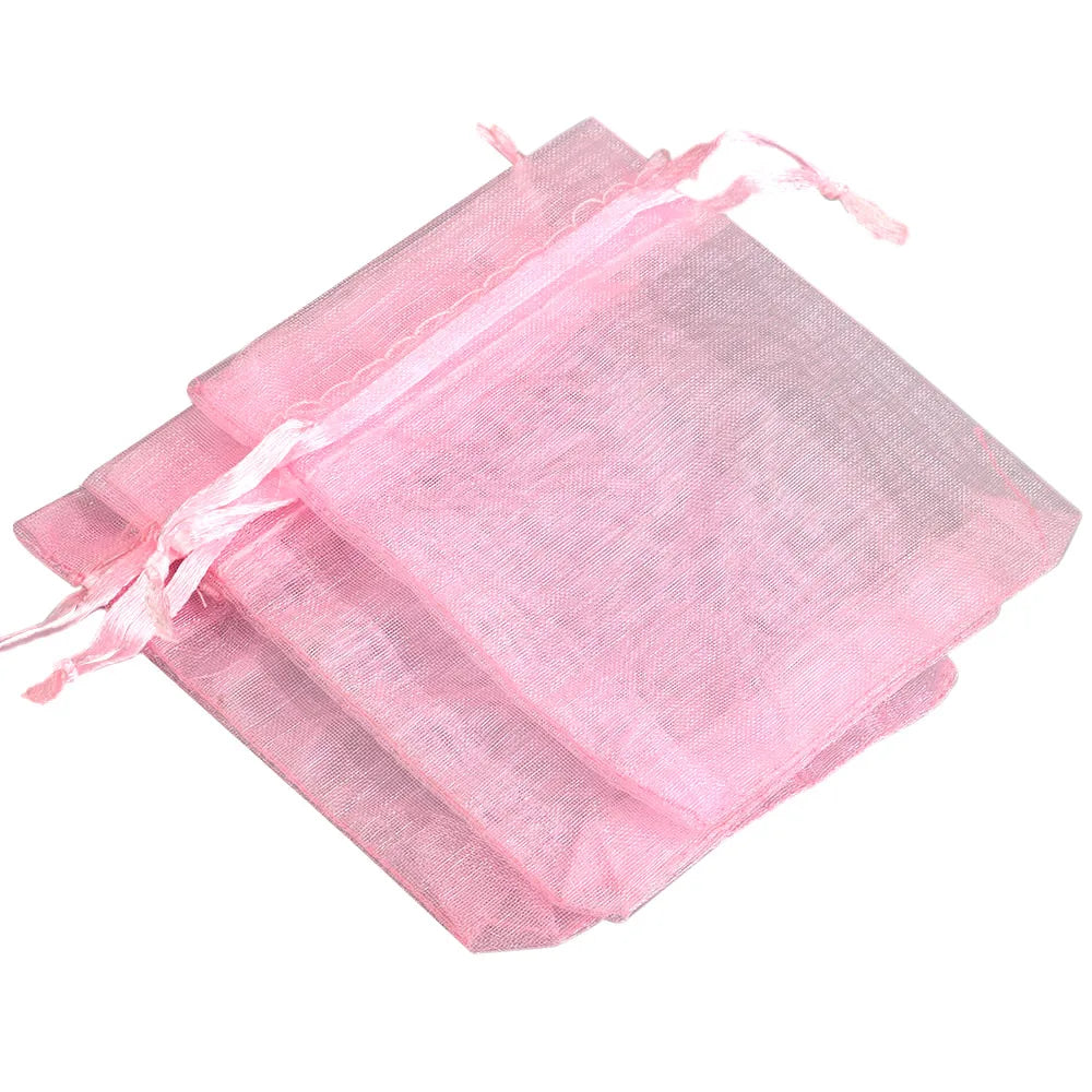 Pink organza drawstring gift pouches stacked and tied with pink ribbon