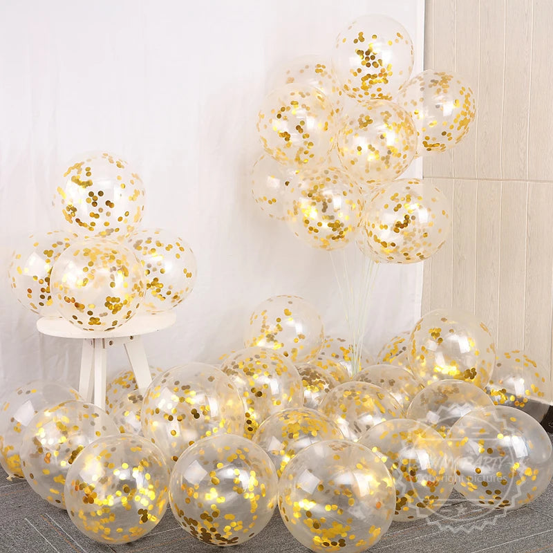 Un grupo de globos transparentes llenos de confeti dorado y adornos de papel de oro