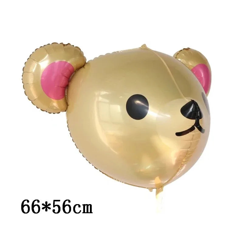 Globo de papel dorado en forma de oso con orejas rosas y rasgos faciales negros.