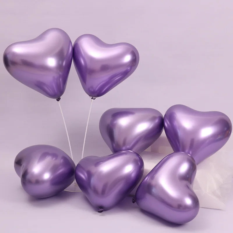 Una colección de globos de aluminio en forma de corazón morado en cuerdas blancas.