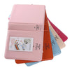 A stack of pink and orange compact photo albums for instant film.