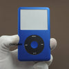 Une main tient un appareil bleu avec une face blanche et un bouton circulaire noir, probablement un kit de réparation iPod Cl