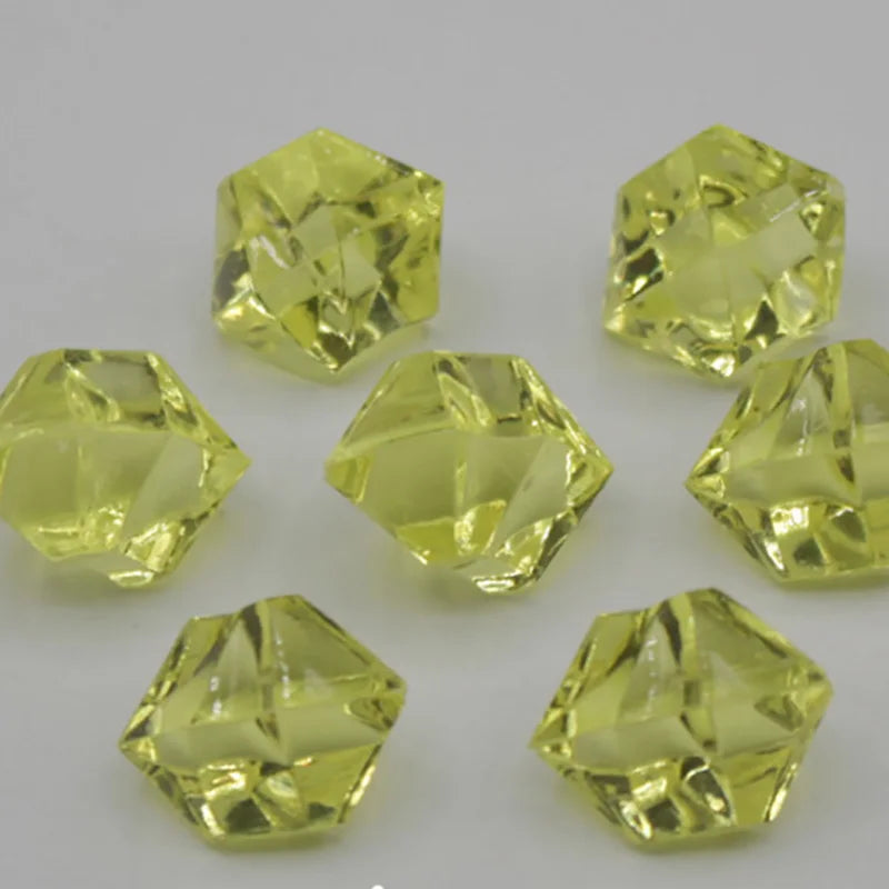 Several faceted yellow acrylic crystals used as party decorations