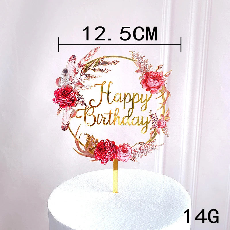 Rose gold acrylic happy birthday wreath with pink and red flowers on a white cake.