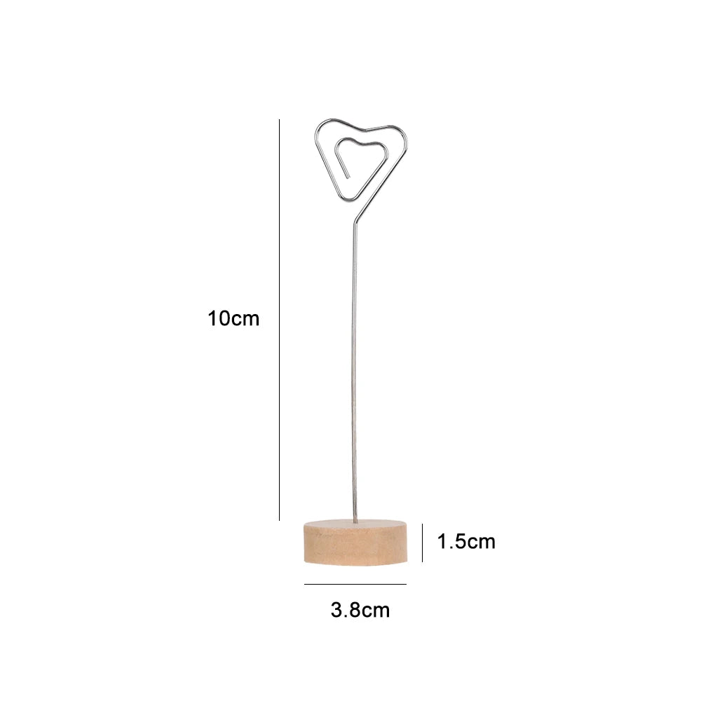 A silver heart-shaped photo frame with a wooden base and a long metal rod.