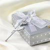 Silver crystal rose artificial flower with a sheer ribbon bow resting on a gray gift box