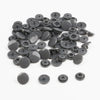 A pile of assorted dark gray snap buttons, measuring 12mm and 10.5mm, for crafting.