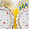 A stack of colorful cartoon-themed disposable paper plates for parties, featuring bright colors and festive designs.