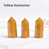 Three yellow aventurine crystal point prisms displayed on a white surface.
