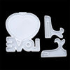 White silicone mold pieces shaped like a heart and letters for DIY photo frames
