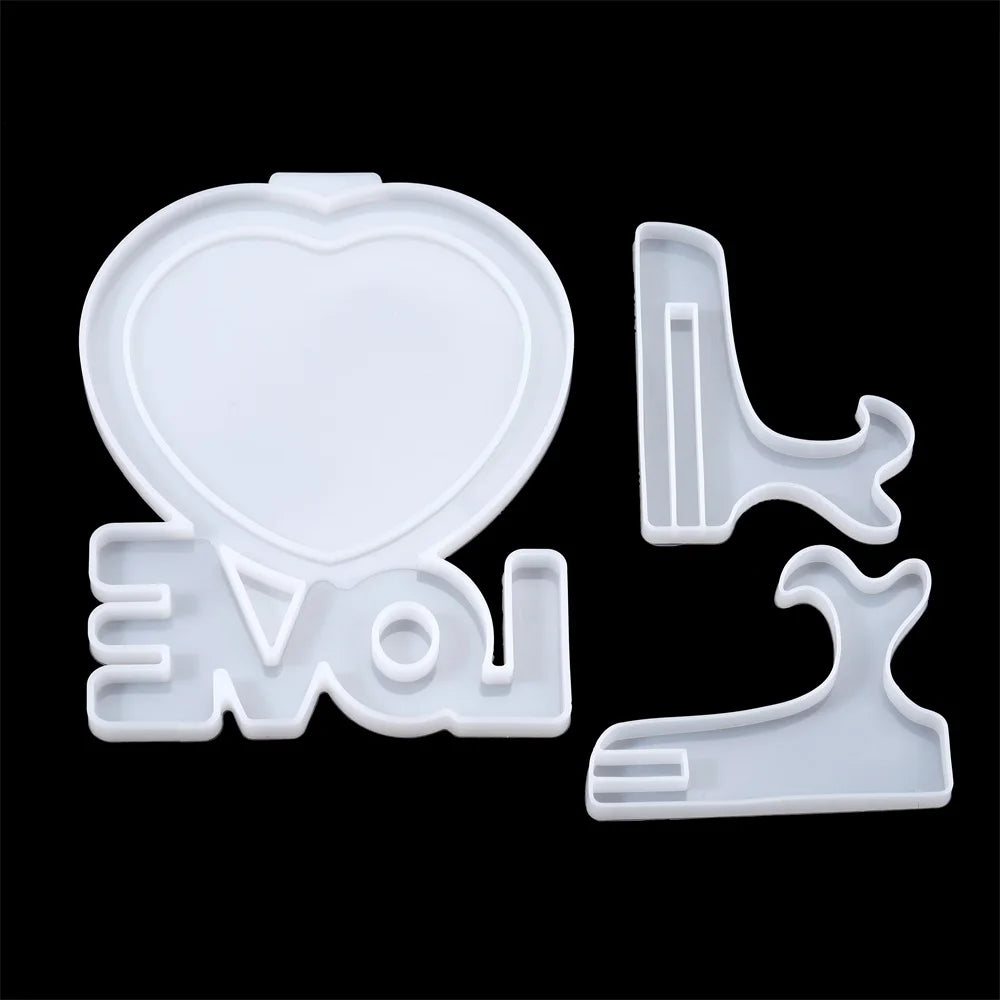 White silicone mold pieces shaped like a heart and letters for DIY photo frames