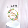 Rose gold acrylic happy birthday cake topper featuring floral accents on a white cake.