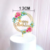 Rose gold acrylic happy birthday cake topper featuring pink roses and green foliage on a white cake.