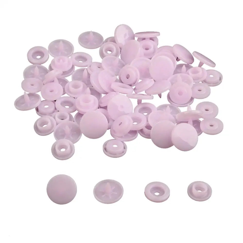 A pile of assorted pink snap buttons, including 12mm and 10.5mm sizes, for crafting.