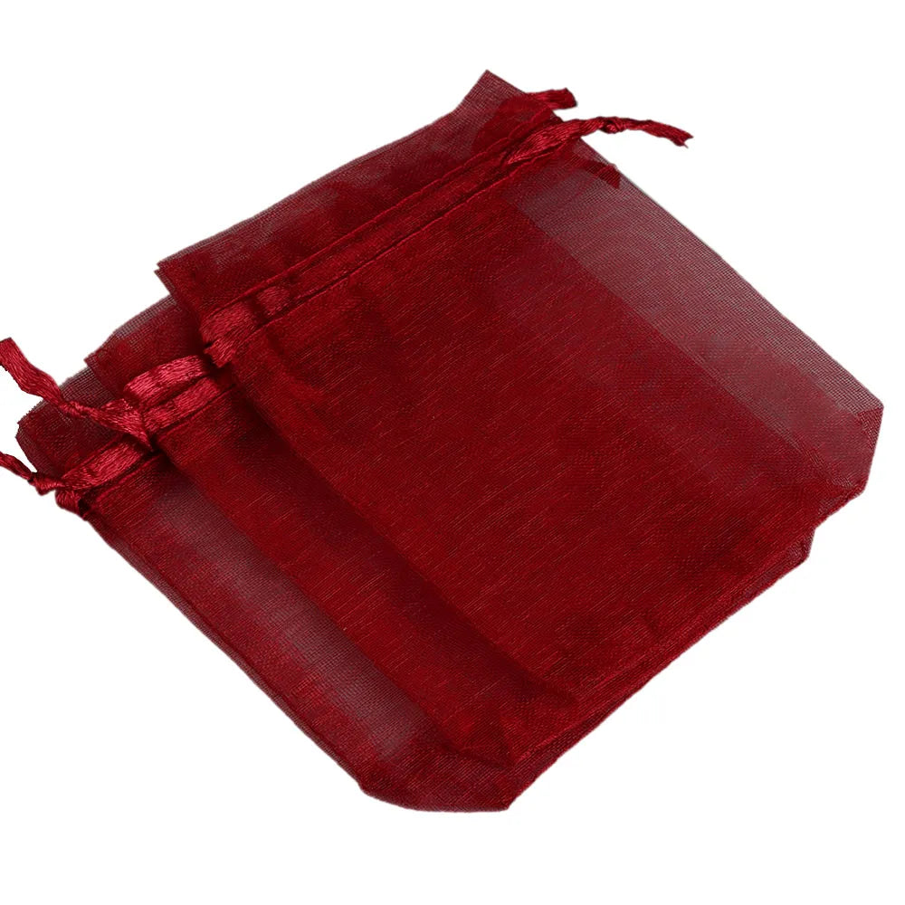 A stack of deep red organza drawstring gift pouches for jewelry, candy, or party favors.