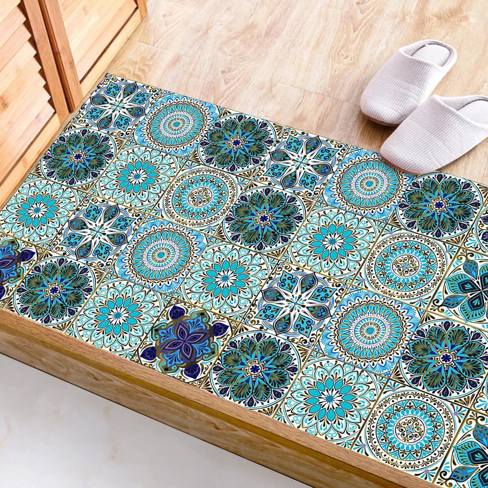 A rectangular tile featuring intricate blue and teal mandala patterns, displayed next to a pair of beige slippers.