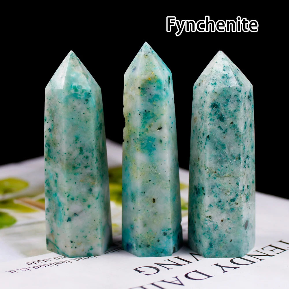 Three vertical points of cyan green funchenite crystals displayed on a white surface.