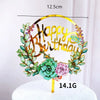 Rose gold acrylic happy birthday wreath with green foliage on a white cake.