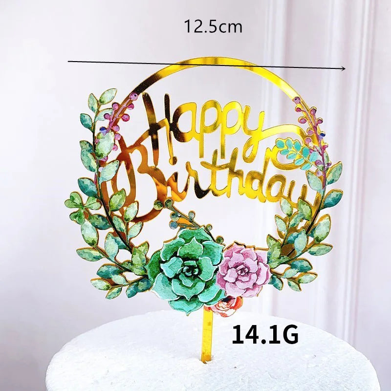 Rose gold acrylic happy birthday wreath with green foliage on a white cake.