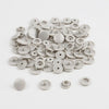 A pile of assorted silver and white snap buttons, measuring 12mm and 10.5mm, for crafting.