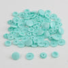 A pile of assorted light blue snap buttons, measuring 12mm and 10.5mm, for crafting.