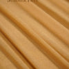 Close-up of sheer chiffon fabric in a warm beige tone draped and folded