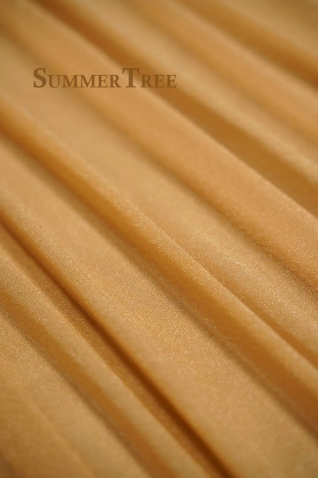 Close-up of sheer chiffon fabric in a warm beige tone draped and folded