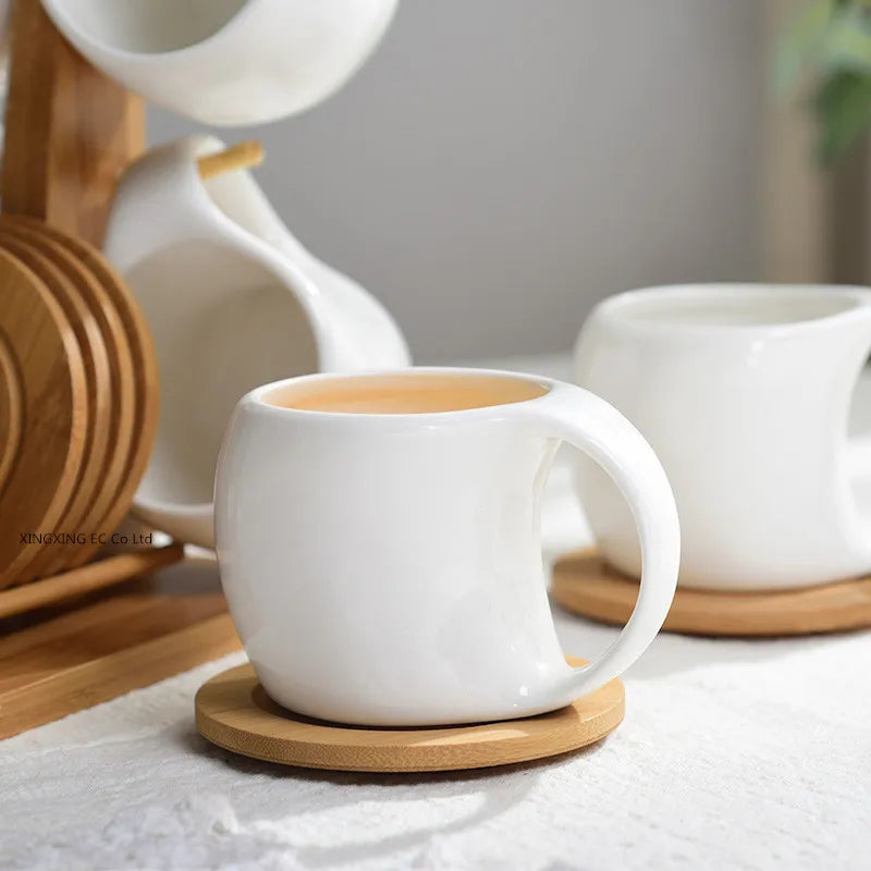 White ceramic coffee mugs displayed on natural bamboo wood stands.