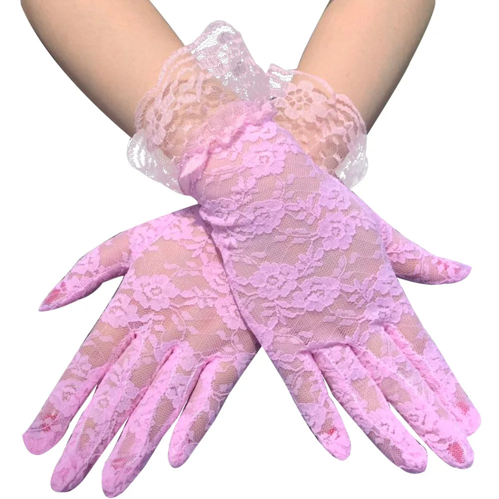 Pair of sheer pink lace gloves worn on a hand and arm.