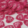 Pink heart-shaped sponge confetti scattered on a white surface for weddings and celebrations