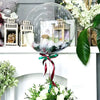 Clear balloons filled with greenery and flowers displayed on a white mantelpiece.