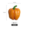 A realistic orange bell pepper with a green stem, used as a fridge magnet.