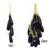 Five dark purple artificial eggplants hanging on twine for decoration