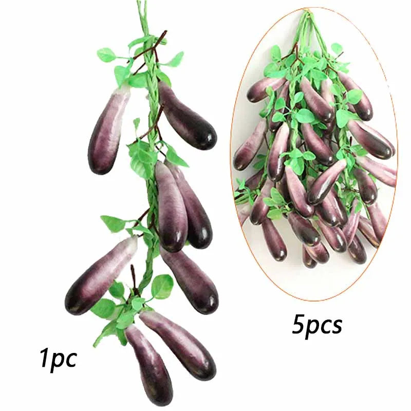 Five dark purple artificial fruits or vegetables hanging on a green vine for decoration