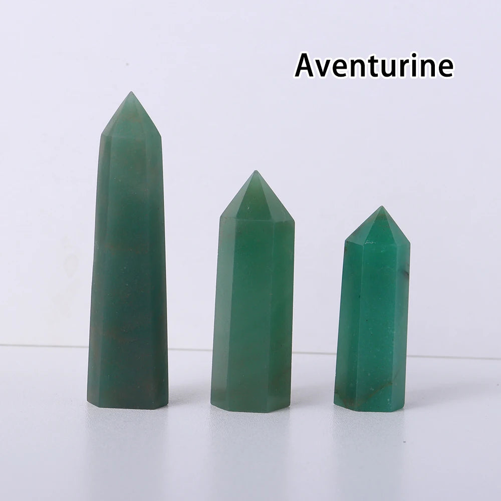 Three green aventurine crystal point prisms displayed on a white surface.
