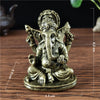 Gold Ganesha statue handcrafted resin figurine sitting on a wooden surface.