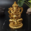 Gold Ganesha statue handcrafted resin figurine with a seated posture on a dark background.