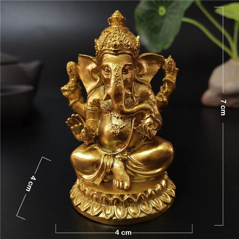 Gold Ganesha statue handcrafted resin figurine with a seated posture on a dark background.