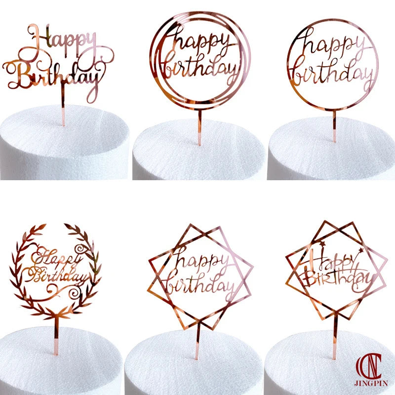 Rose gold acrylic happy birthday cake toppers in various designs on white cake boards