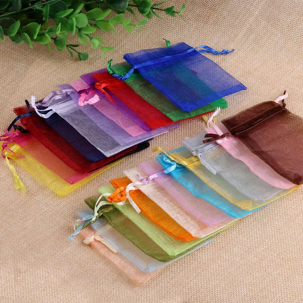 A colorful display of organza drawstring gift pouches in various shades of pink, purple, blue, green, and orange.