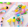 A set of five cute cartoon mini ballpoint pens in various colors and designs laid out on a sheet of graph paper.