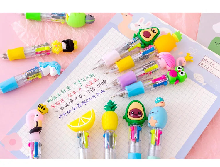 A set of five cute cartoon mini ballpoint pens in various colors and designs laid out on a sheet of graph paper.